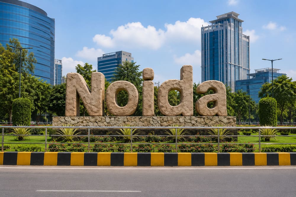 Noida stone landmark sign with office towers behind it